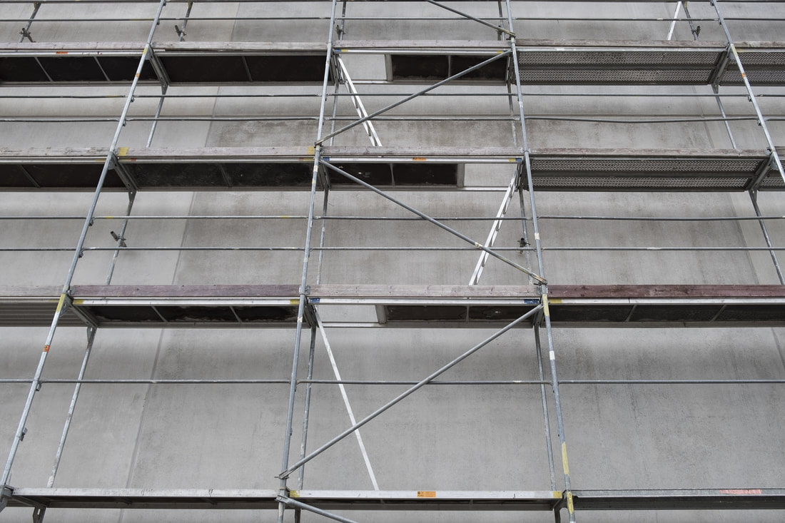 Picture of a multi-level independent scaffold against a concrete wall 